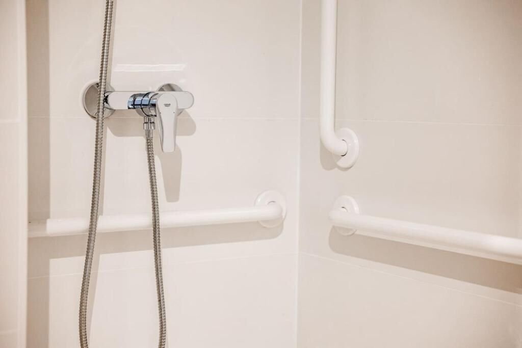 Ducha con barras de apoyo en el baño adaptado